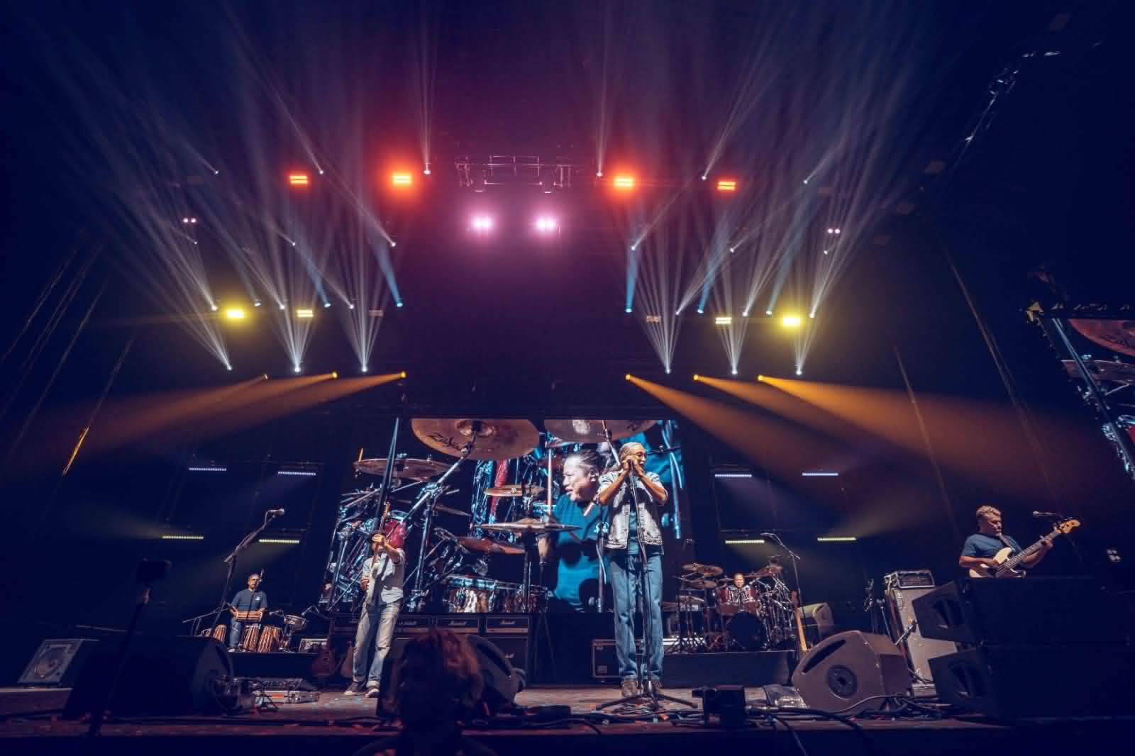 Full band performing on a wide festival stage